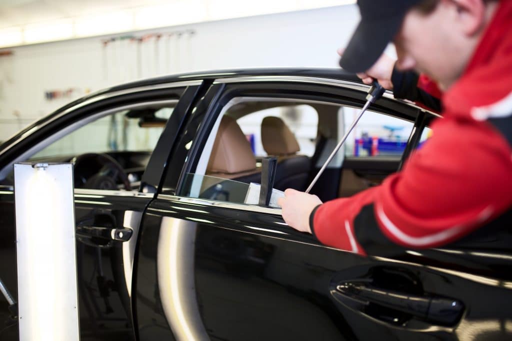 Un débosseleur retire une bosse d'une porte d'une voiture